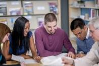 Adult students at a table studying together.